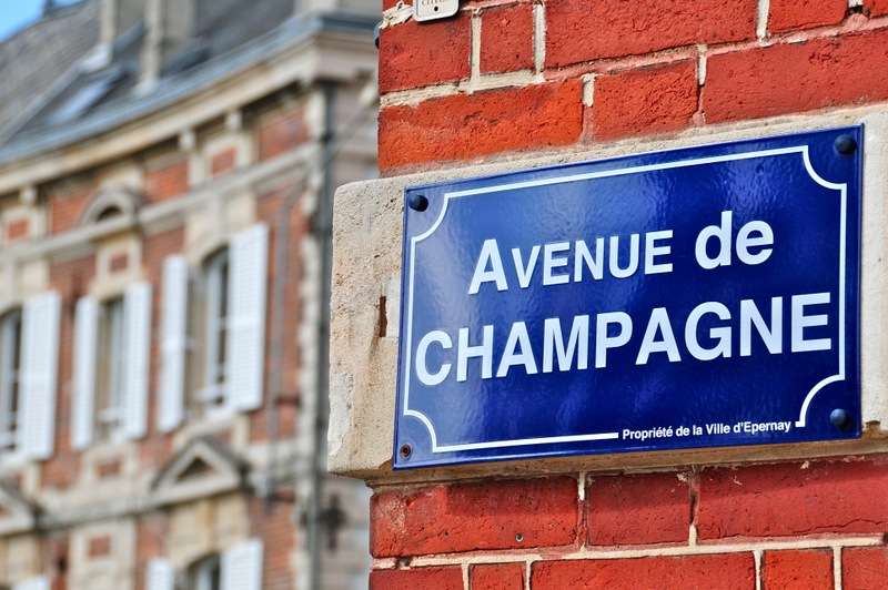 Avenue de champagne Blue sign in Epernay against red brick wall