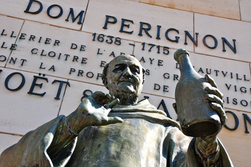 Top of Dom Peerignon statue in Epernay with plaque behind with description of the inventor of champagne