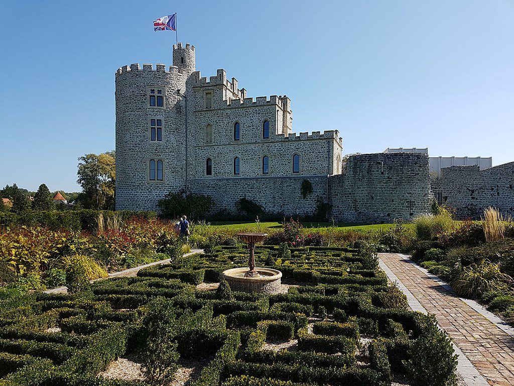 Hardelot Chateau of white stone with 3-storeyround tower with flag flying and adjacent swquare building of 1 and 2 storeys. Formal parterre gardens in frontCASTLE WITH TOWER AND FLAG FLYING BE