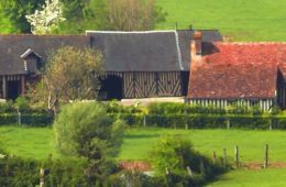 Normandy countryside with half timbered barns, red rooved houses and green pastures
