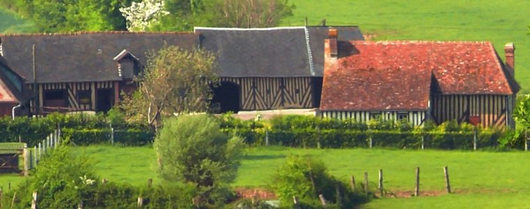 Normandy countryside with half timbered barns, red rooved houses and green pastures