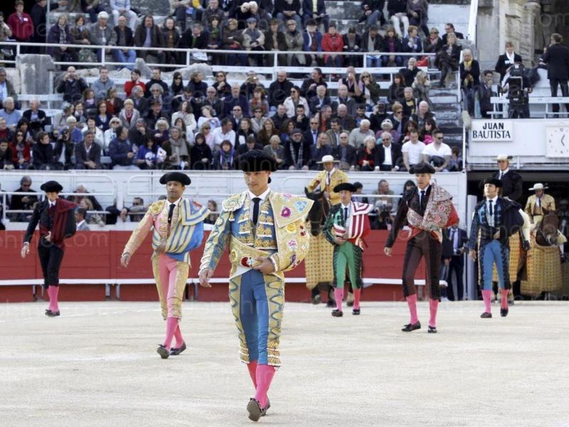 Bull fighters in colourful traditional costumes walking into the arena in Arles for the annual Easter Feria