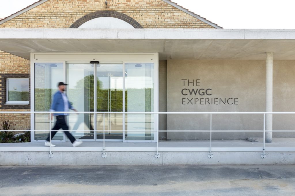 CWGC Experience Entrance with man walking past one storey attactive brick and glass building with name on front © CWGC