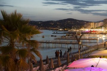 Juan les Pins at night with lit up bars in foreground and sea at back