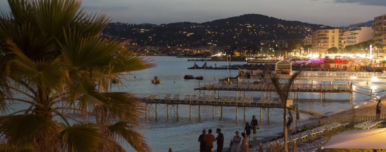 Juan les Pins at night with lit up bars in foreground and sea at back