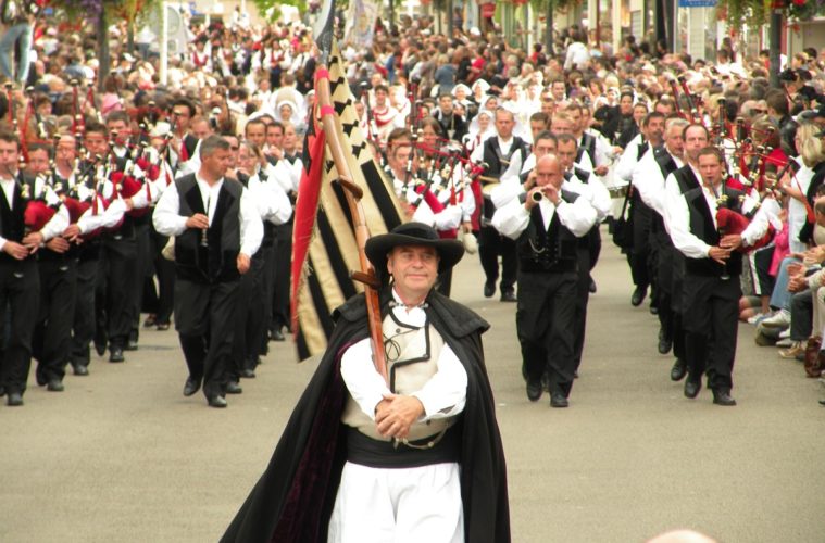 Procession of men with bagpipes in the street at Lorient Interceltic festival