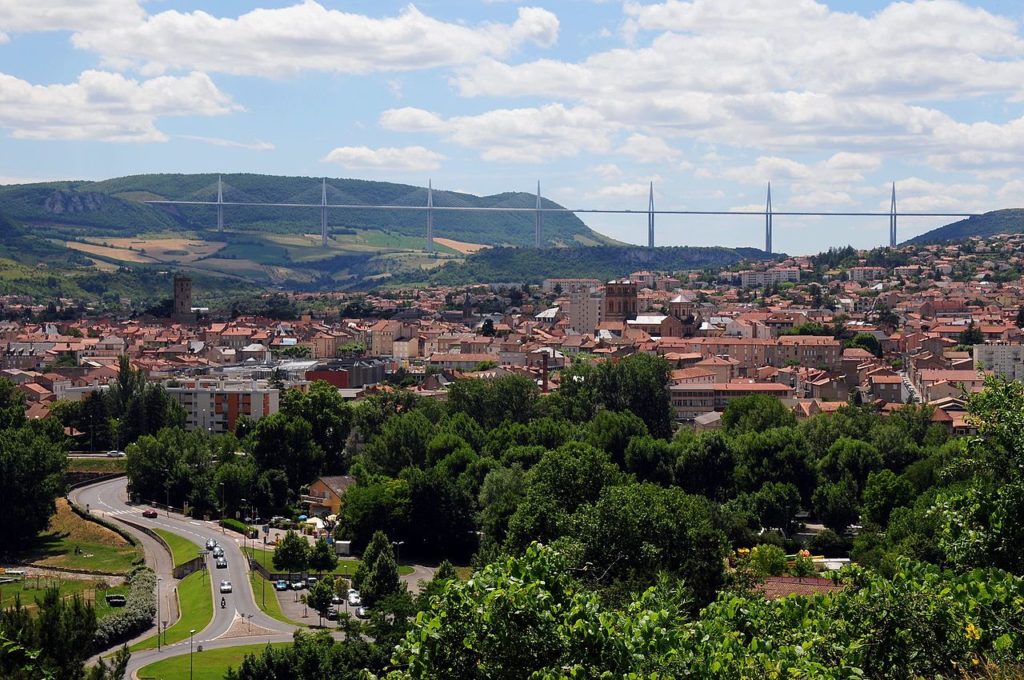 View from afar of the Millau bridge over the Tarn with the town below and the soaring viaduct ahead