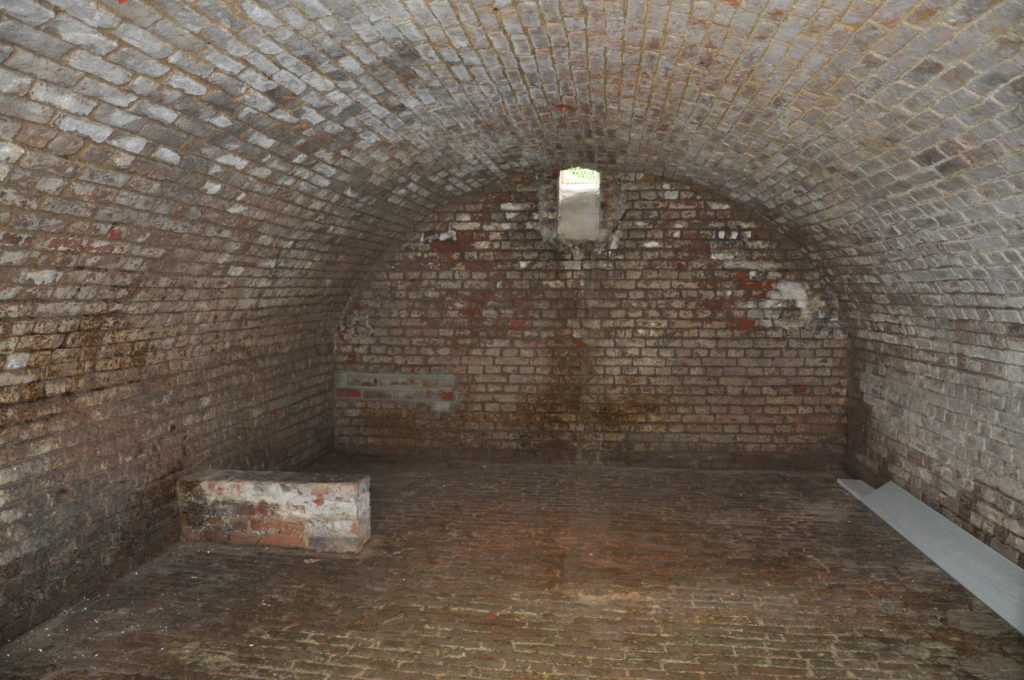 Cellar of the Wilfred Owen Memorial with vaulted roof and no people. Dark and damp
