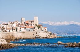 Antibes ramparts and castle seen from afar with snow-covered Alps in background