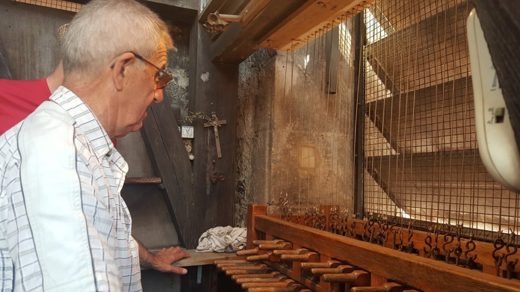 Man playing carrillon bells in church tower in Castres, Tarn