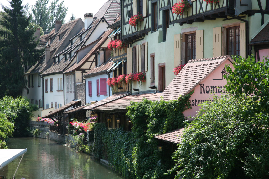 Colmar in Alsace in Spring with small canal running beside pretty houses with terraces