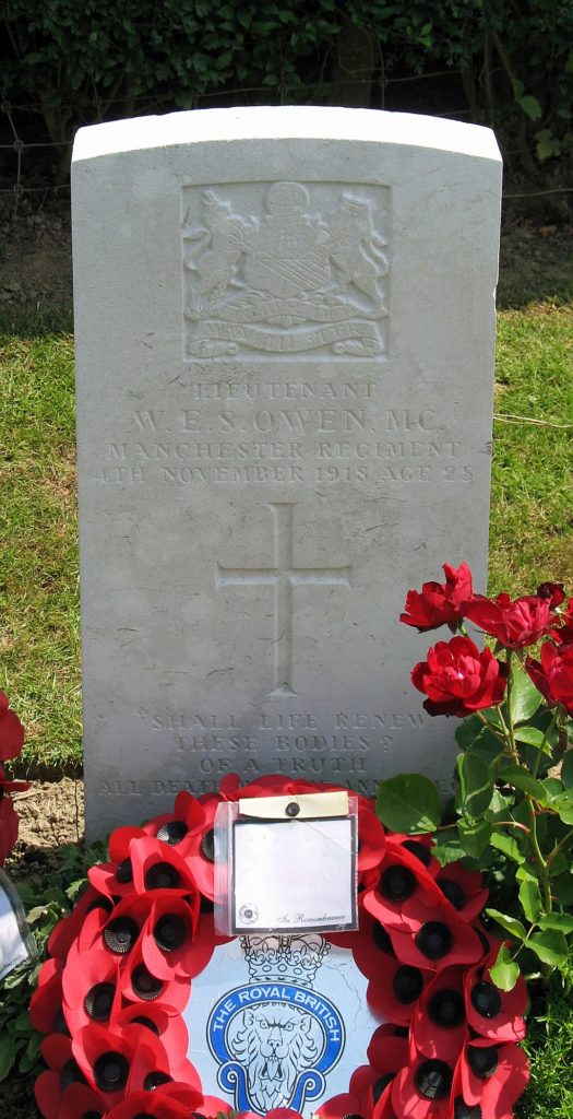 Wilfred Owen's grave in Ors as a single headstone with flowers and wreaths
