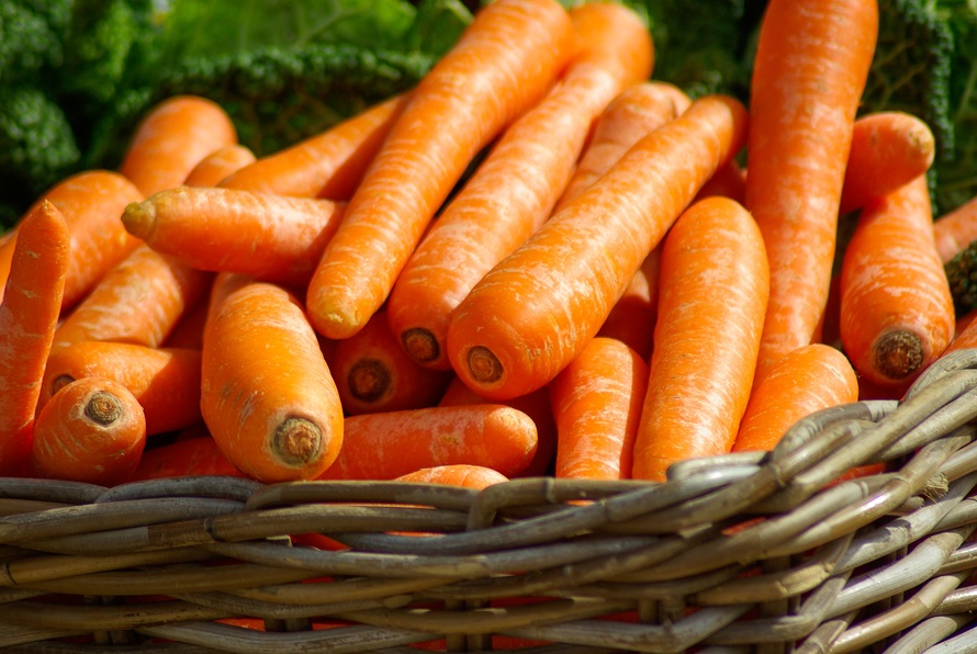 Wicker basket full of bright orange carrots