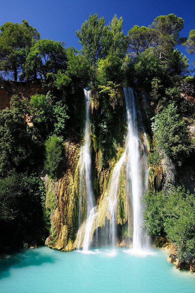 Sillans la Cascade in the Var with a waterfall gushing out from the top of a rock covered with trees and bushes