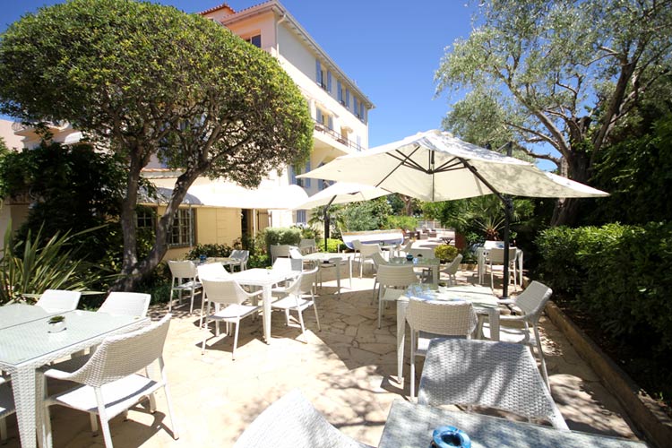 Beau Site Hotel garden with white parasols, tables and chairs