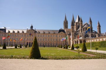 Abbaye aux Hommes stone building with lawn in front in Caen