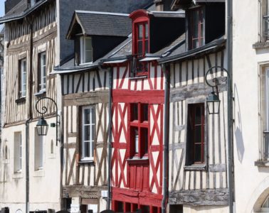 Renaissance houses in Orleans. Facade of three coloured, two grey on side of red half timbered houses