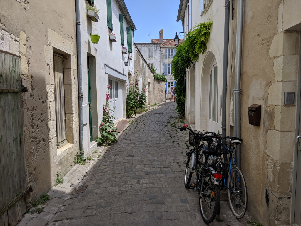 Bicicyles against a wall in narrow cobbled street with stone houses