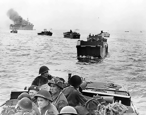 Black and white photo of Canadians landing at Juno Beach. Men on landing craft approaching beach