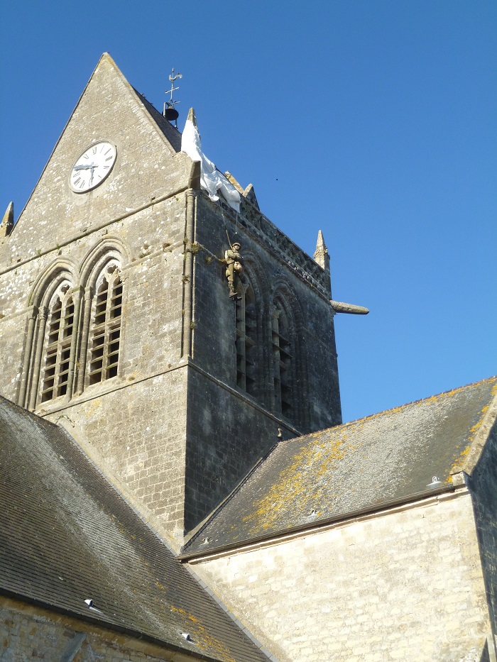 Ste-Mere-Eglise church with model of soldier hanging by parachute from steeple Normandy Landing Beaches