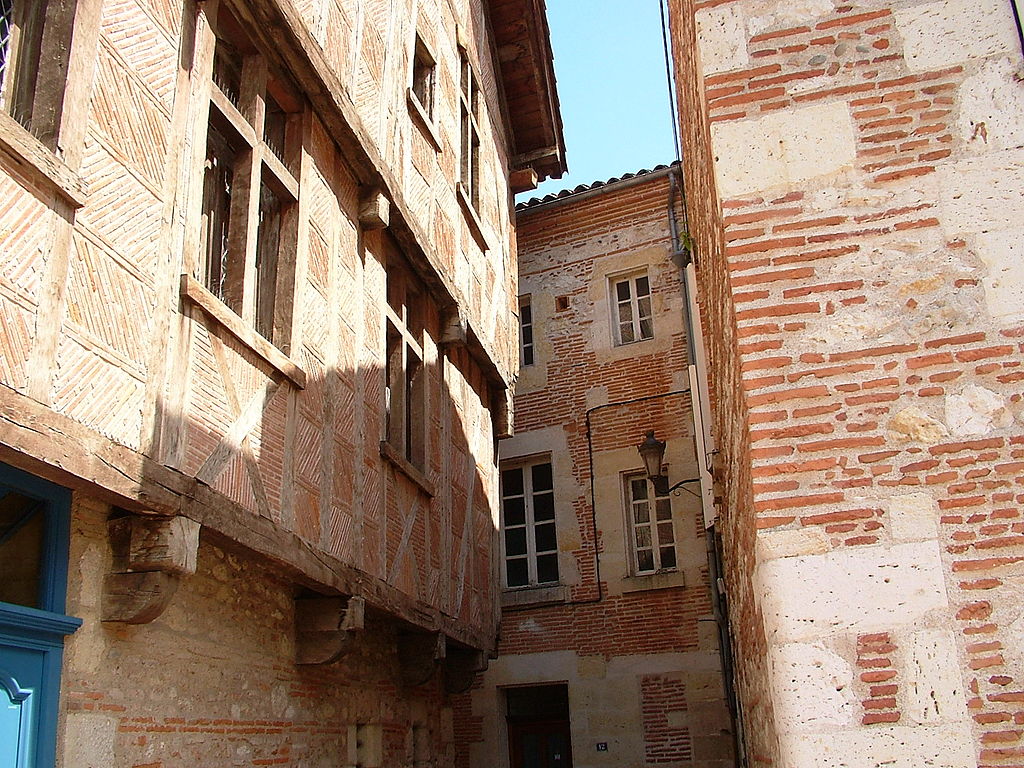 Agen red brick houses. Looking at walls and windows of houses around a very small courtyard