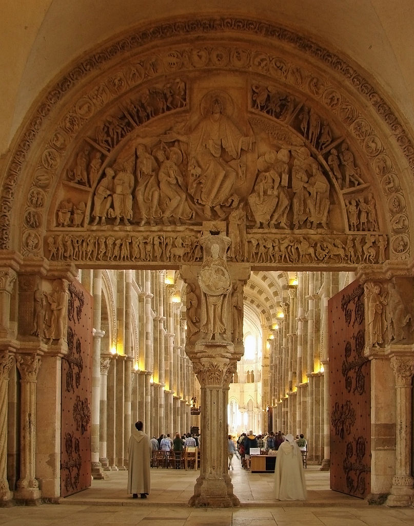 Inside Vezelay basilica looking through internal tympana carved with Christ and fiures into nave stretching away