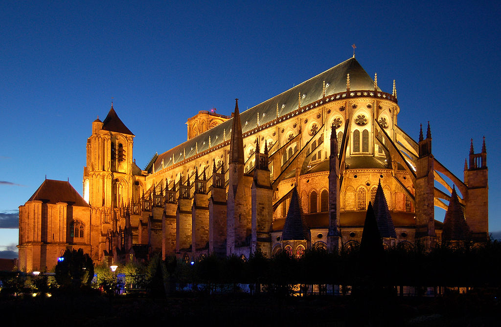 Ground level looking up at Bourges cathedral lit up at night. View from the back towards the front towers