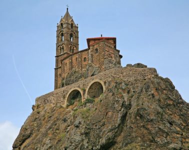 Looking up very high rocky pinacle in Le Puy to the Aiguille of St Michael Pilgrim Walking routes in France