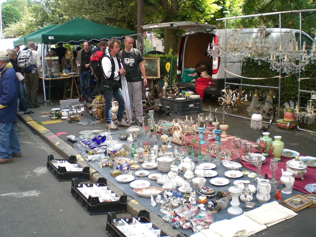 Lille Braderie, flea market in Little with load of china on ground on tarpaulin, boxes in front and people looking at it