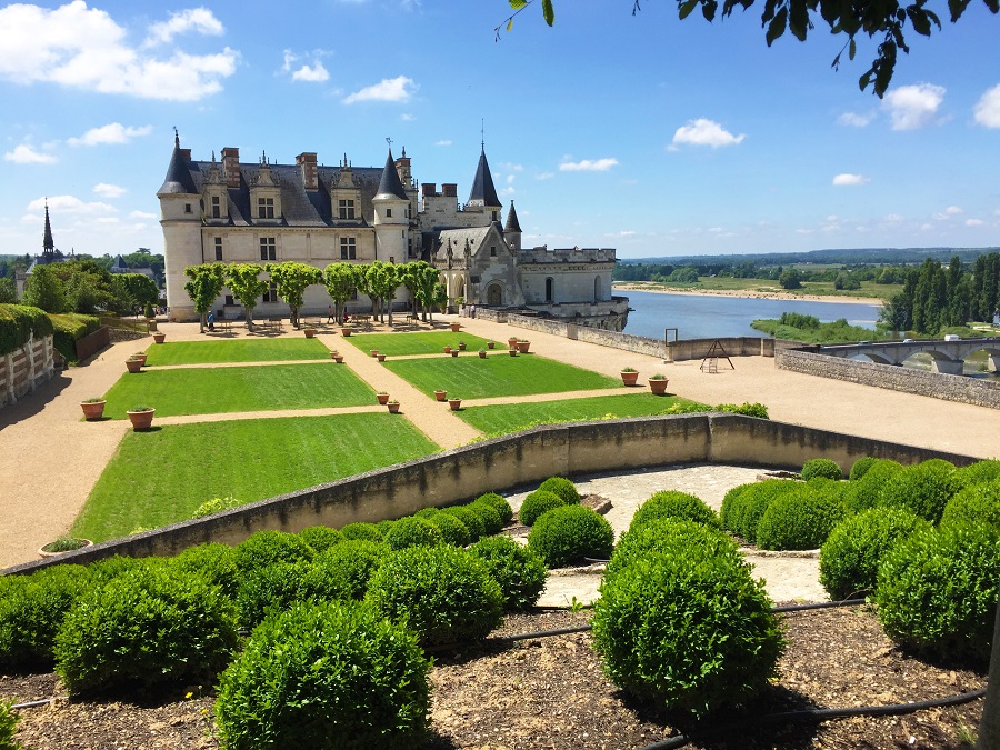 Amboise chateau, white stoned with onion domes with grounds and flower beds in front and Loire river below on right