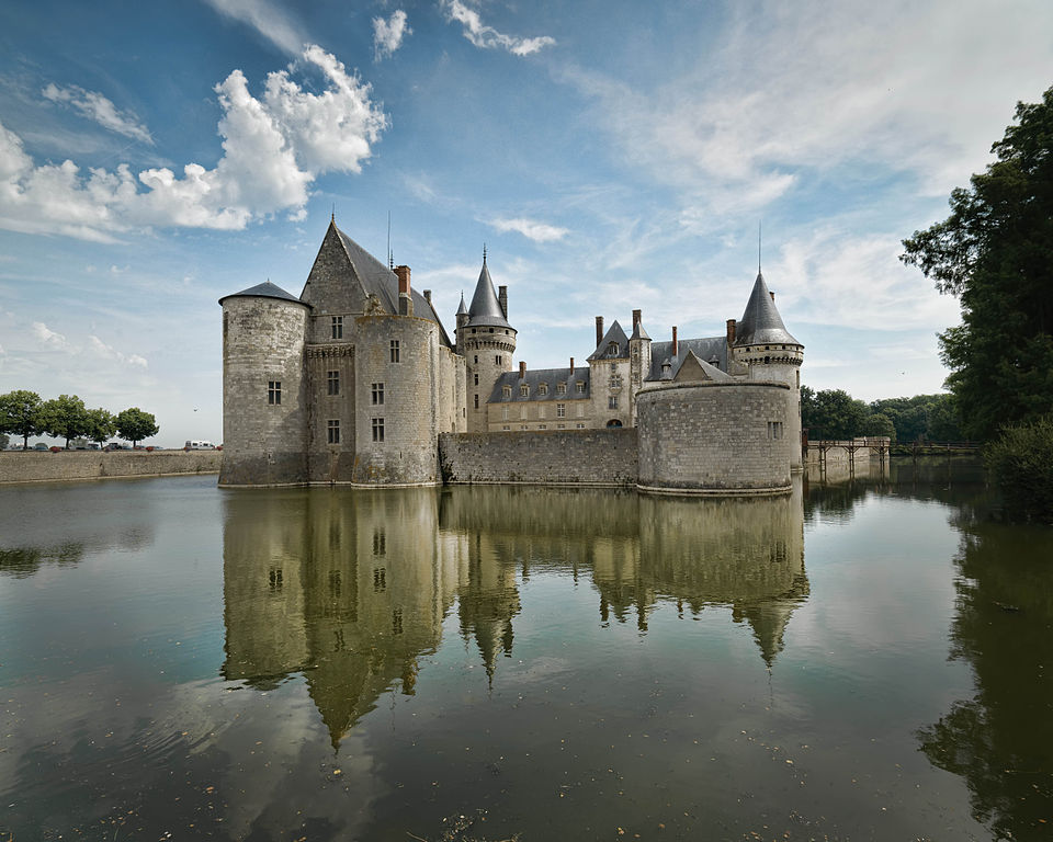 Chateau de Sully-sur-Loire with fairytale castles in waters reflected, towers, onion domes, sky with white clouds
