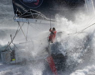 Boris Herrman in racing boat for Vendee Globe. Looking down through a p0lume of spray to the lone sailor