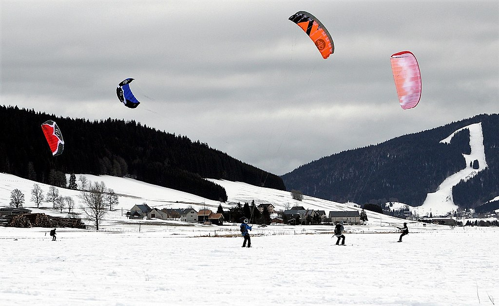 Autrans Festival with skiers attached to huge colourful kites pulling them along