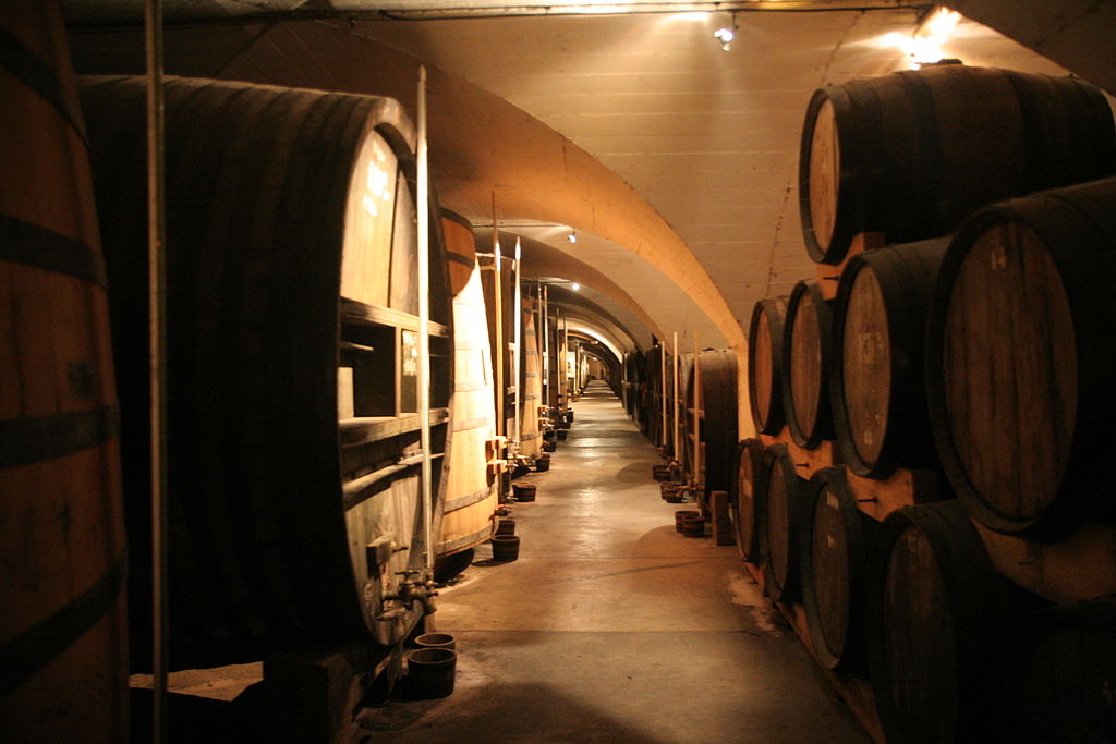 Chartreuse cellars with old wooden huge oak barrels running down each side of vaulted cave