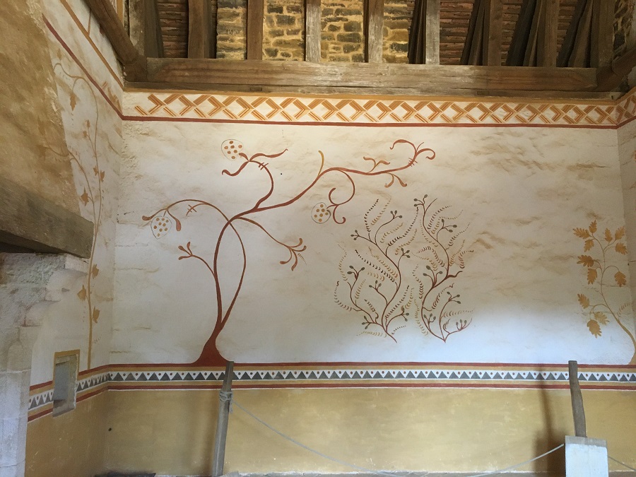 Wall decoration showing tree in ochre on white background in top panel at bedchamber at Guedelon with timbered vaulted roof above