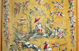 Aubusson tapestry showing bright yellow/orange background and chinoiserie scene of Chinese people with borders of woven flower garlands