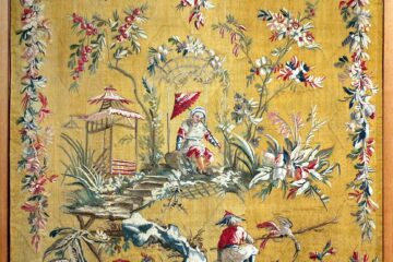Aubusson tapestry showing bright yellow/orange background and chinoiserie scene of Chinese people with borders of woven flower garlands