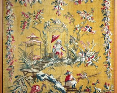 Aubusson tapestry showing bright yellow/orange background and chinoiserie scene of Chinese people with borders of woven flower garlands
