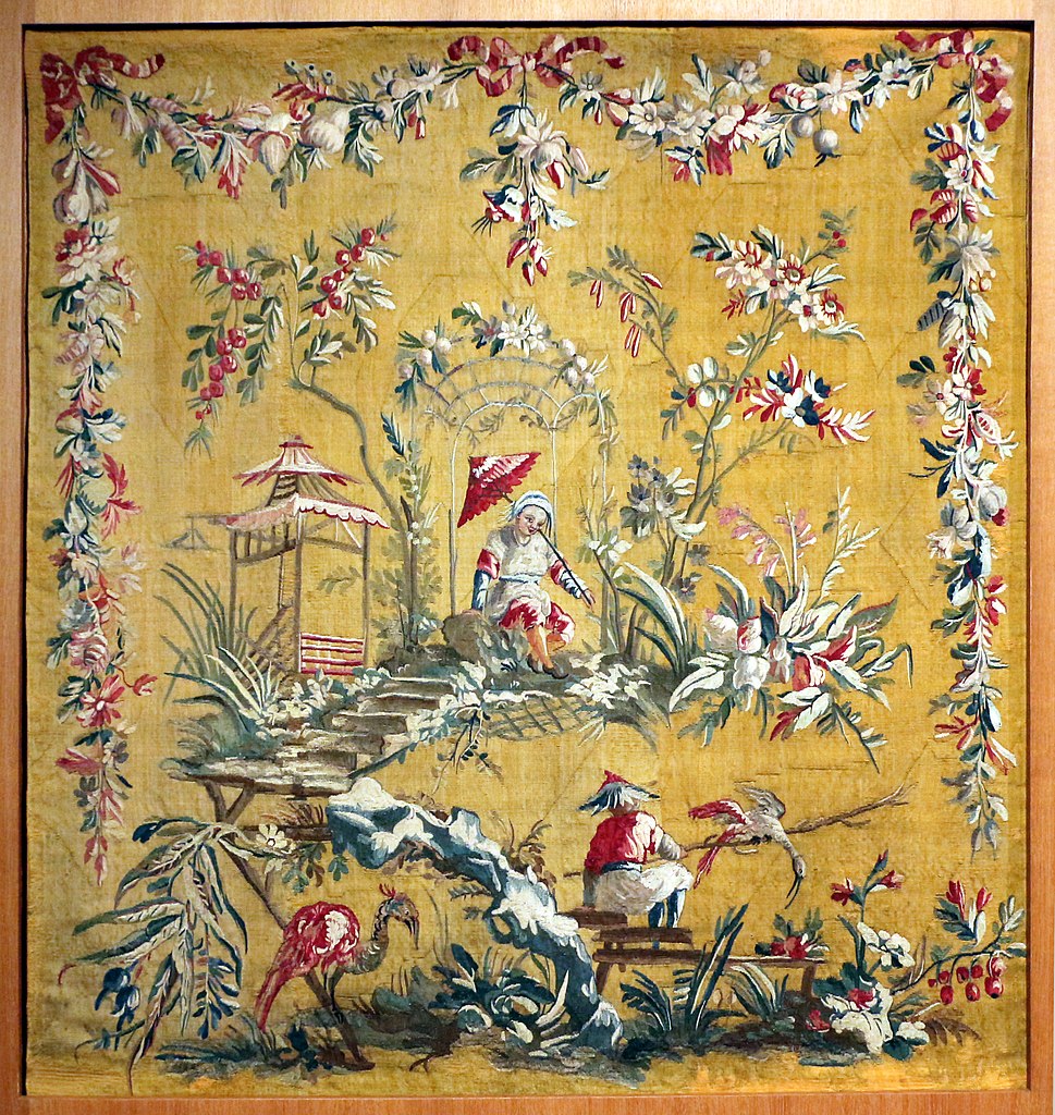 Aubusson tapestry showing bright yellow/orange background and chinoiserie scene of Chinese people with borders of woven flower garlands