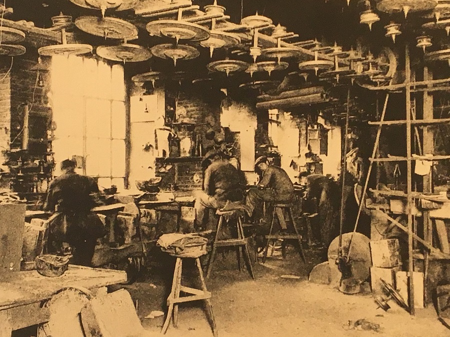 Sepia old photo of 19th century knife makers in crowded factory