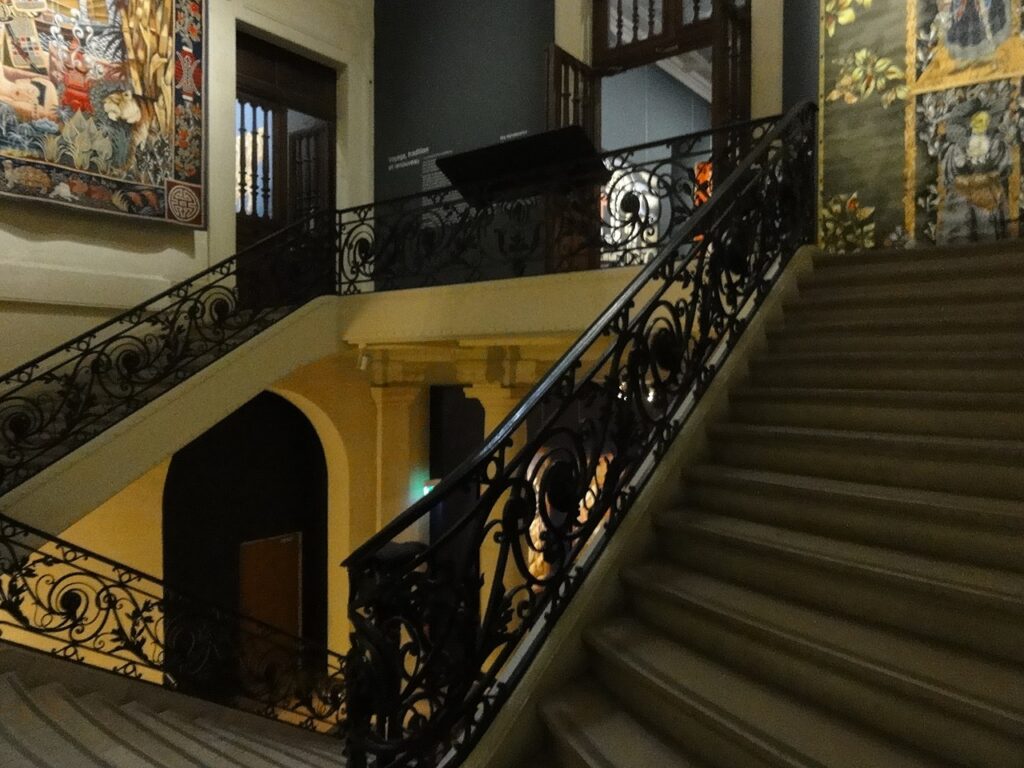 Manufacture des Gobelins showing old building with elegant staircase leading up to a small gallery