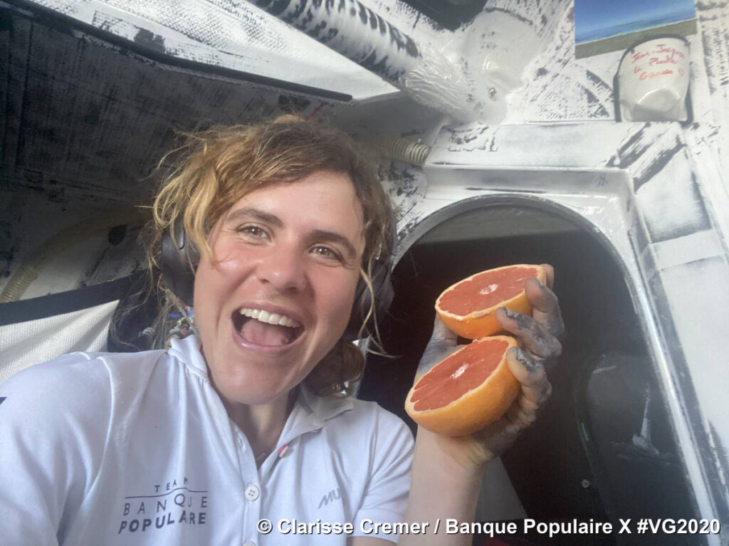 Clarisse Kremer in Vendee Globe race holding up two halves of grapefruit saying 'Yay!' clearly