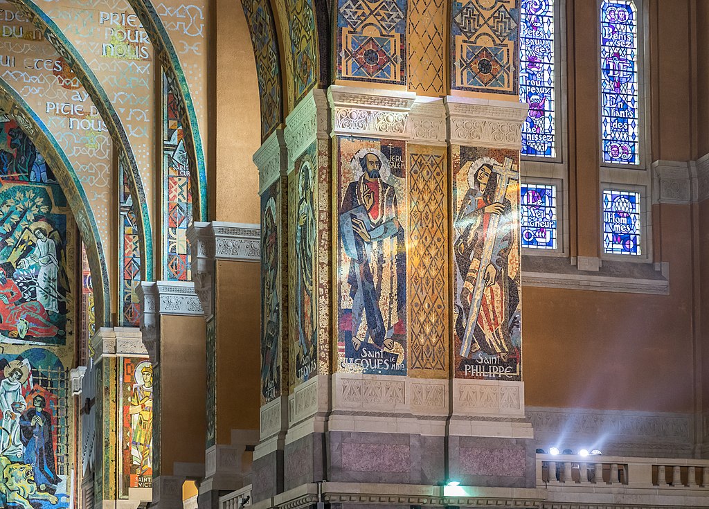 Interior of Basilica of St Therese of Lisieux showing multicoloured capital pillars at sideways angle