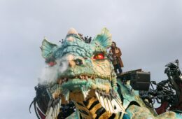 Calais Dragon facing camaera with steam coming out of nostrels and man on top manipulating him