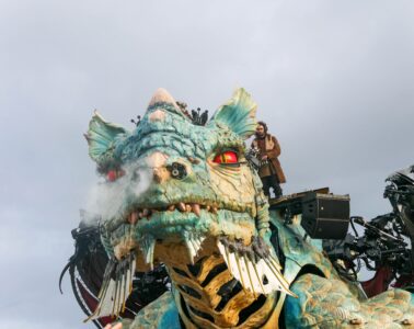 Calais Dragon facing camaera with steam coming out of nostrels and man on top manipulating him