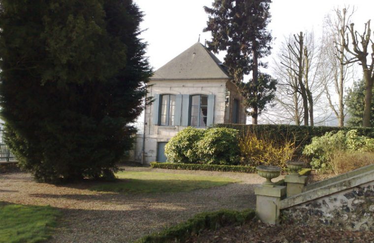 Pavillon Flaubert showing small square building at end of garden against one walls with slate roof