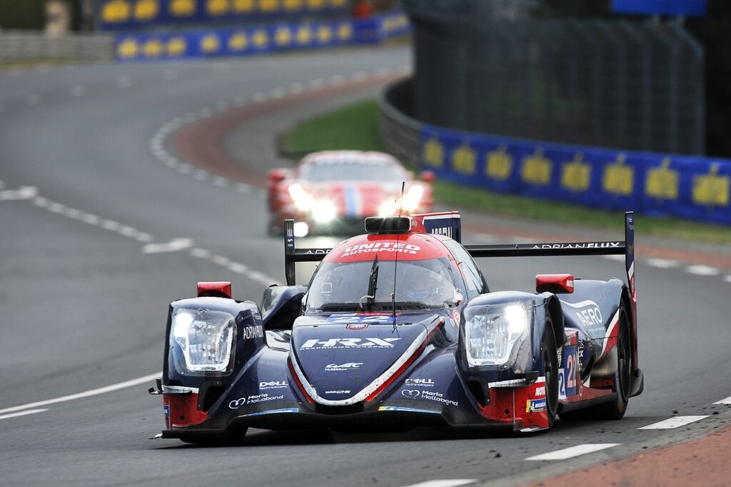 Le Mans 24 hour race with one leading car coming round bend and second behind