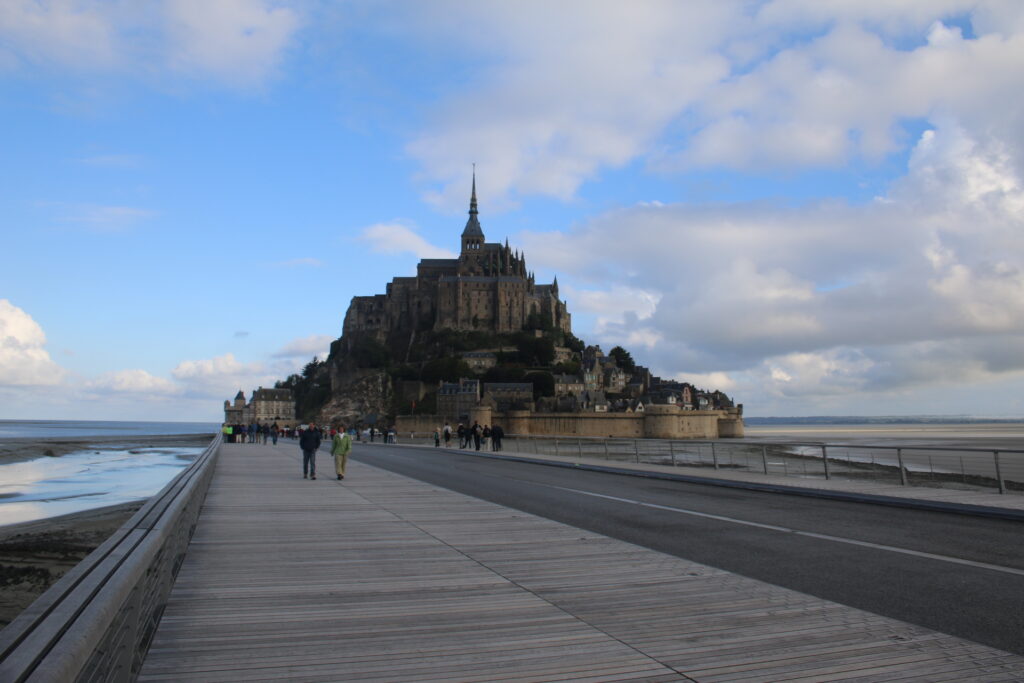 View from the bridge crossing the bay to Mont St Michel with people walking