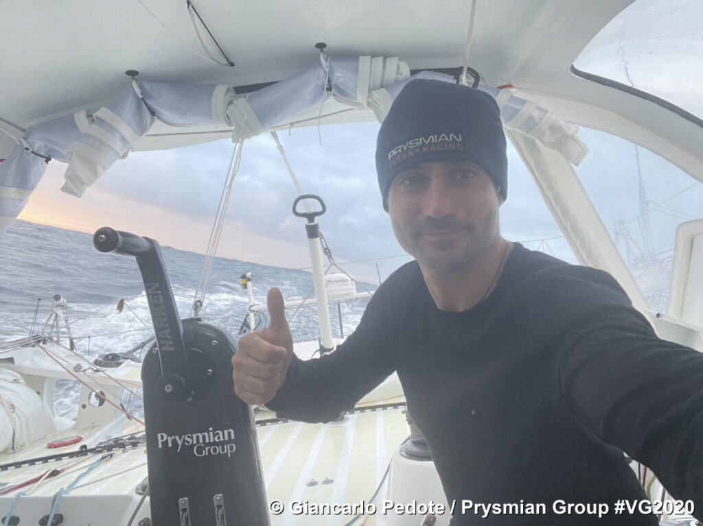 Giancarlo Pedote Prysmian Group selfie of him at back of boat undercover with fair seas behind
