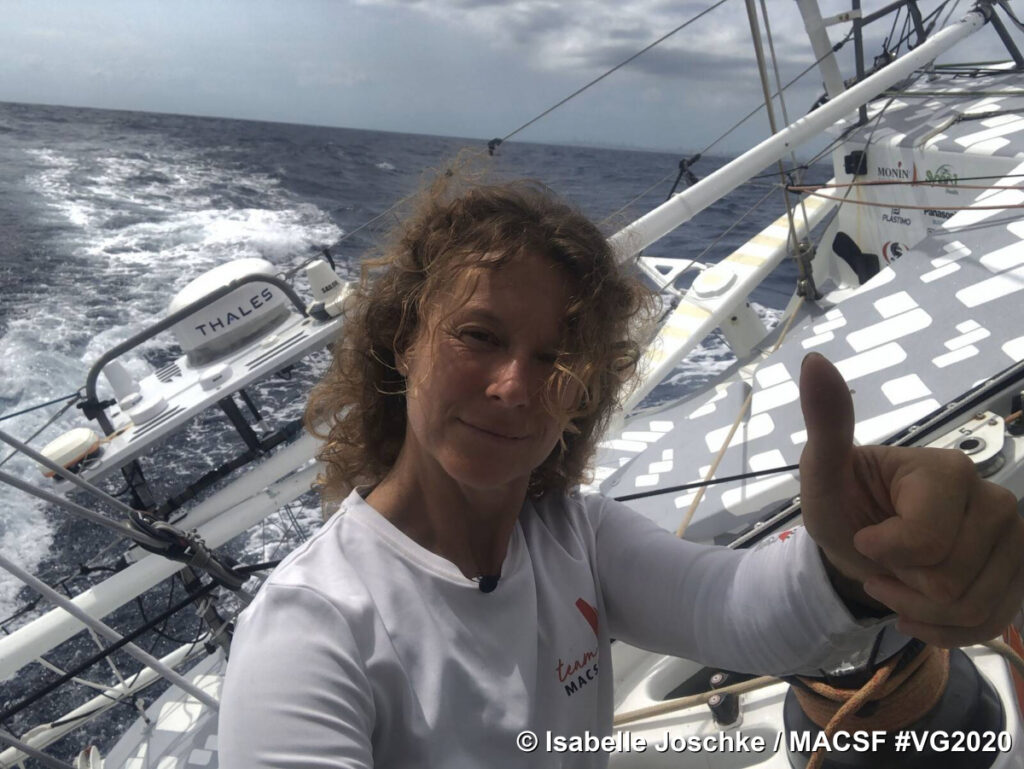 Isabelle Joschke on MACSF in the Vendee Globe race with thumbs up selfie against moderate waves